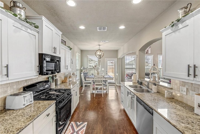 kitchen with white cabinets, sink, hanging light fixtures, and black appliances