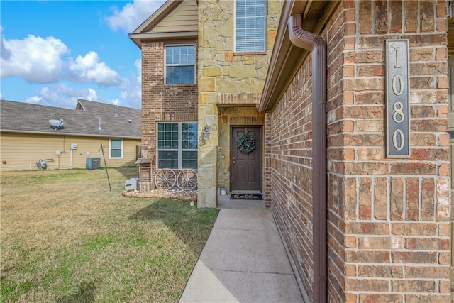 doorway to property featuring central AC and a lawn