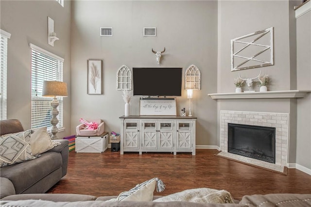 living room with dark wood-type flooring and a fireplace