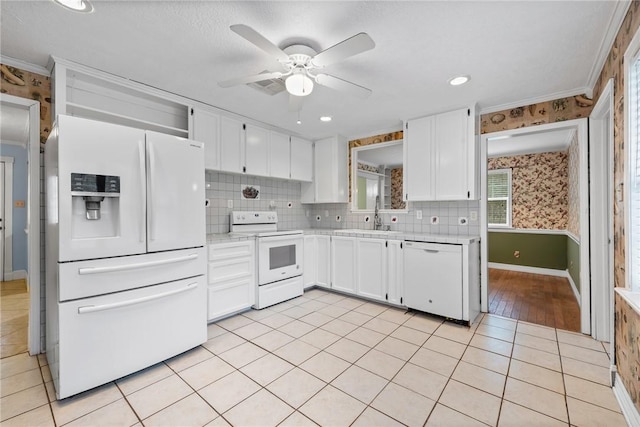 kitchen with white appliances, white cabinets, sink, ceiling fan, and light tile patterned flooring