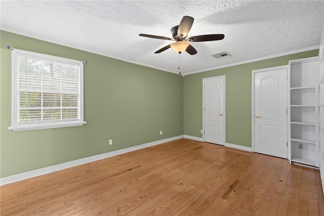 unfurnished bedroom featuring ceiling fan, crown molding, wood-type flooring, and a textured ceiling