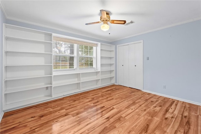 unfurnished bedroom featuring light wood-type flooring, ceiling fan, and crown molding