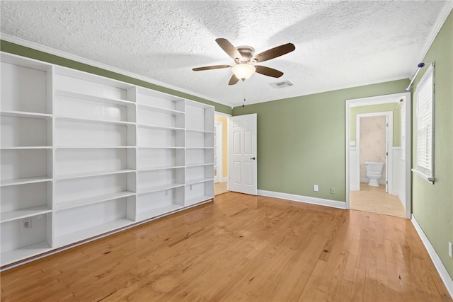 unfurnished bedroom featuring ensuite bath, ceiling fan, a textured ceiling, and light wood-type flooring