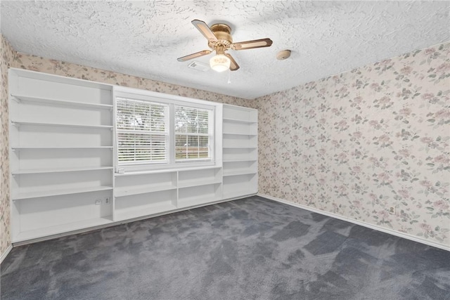 unfurnished room featuring ceiling fan, a textured ceiling, and dark colored carpet