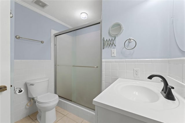 bathroom with an enclosed shower, vanity, tile walls, tile patterned flooring, and toilet