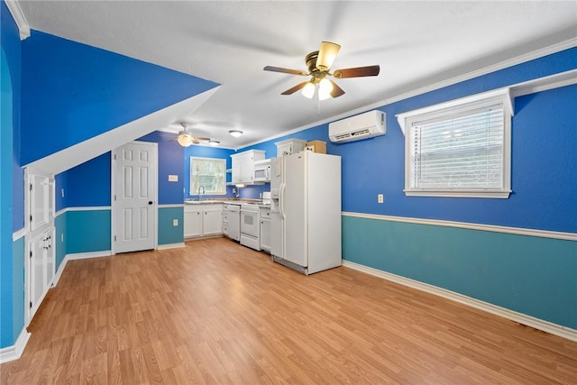 kitchen with white appliances, white cabinets, an AC wall unit, sink, and light hardwood / wood-style floors