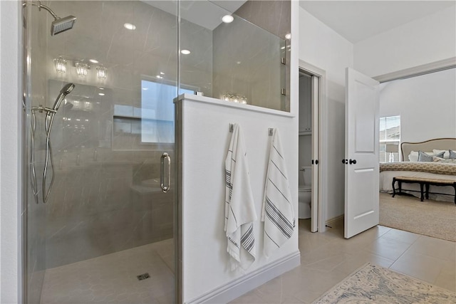 full bath featuring connected bathroom, toilet, tile patterned flooring, and a stall shower