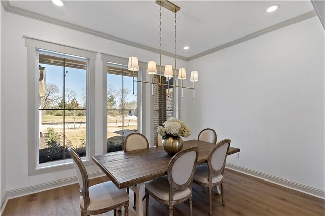 dining room featuring recessed lighting, baseboards, an inviting chandelier, crown molding, and wood finished floors