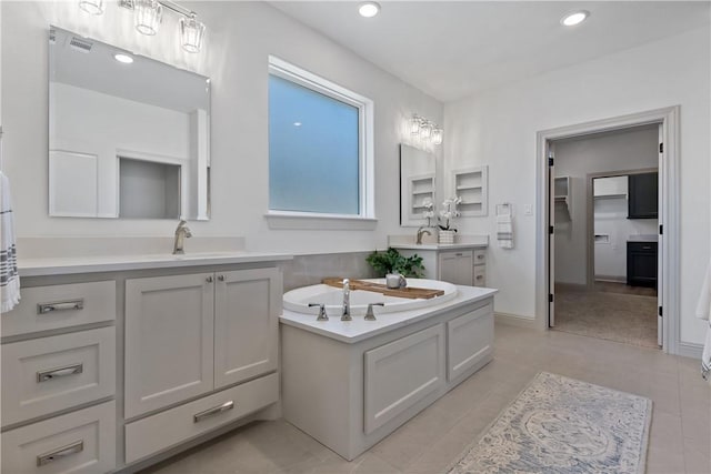 bathroom featuring a sink, two vanities, tile patterned floors, a bath, and recessed lighting