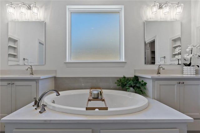 bathroom with a garden tub, two vanities, and a sink
