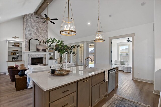 kitchen featuring dishwasher, ceiling fan with notable chandelier, open floor plan, and a sink
