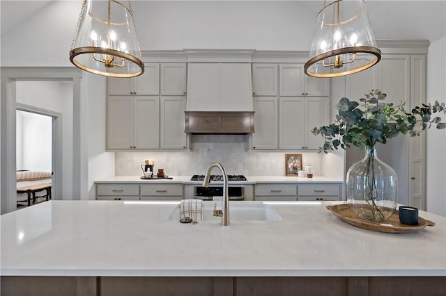 kitchen featuring gray cabinetry, a notable chandelier, light countertops, and hanging light fixtures