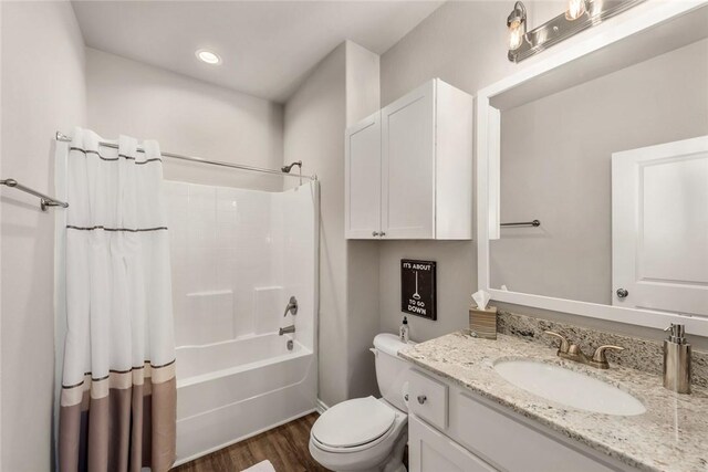 full bathroom with vanity, hardwood / wood-style floors, shower / tub combo, and toilet