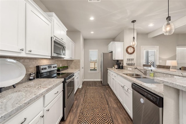 kitchen featuring hanging light fixtures, stainless steel appliances, light stone countertops, decorative backsplash, and white cabinets