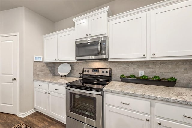 kitchen with tasteful backsplash, white cabinetry, dark hardwood / wood-style flooring, light stone counters, and stainless steel appliances