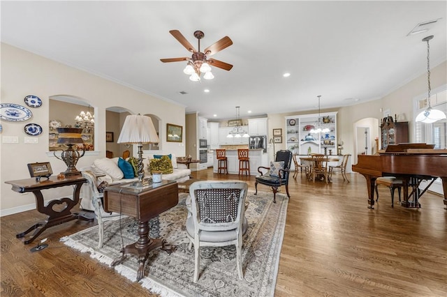 living room with hardwood / wood-style flooring, ceiling fan, and ornamental molding