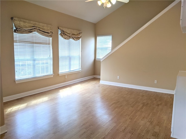 unfurnished room featuring ceiling fan, light hardwood / wood-style floors, and vaulted ceiling