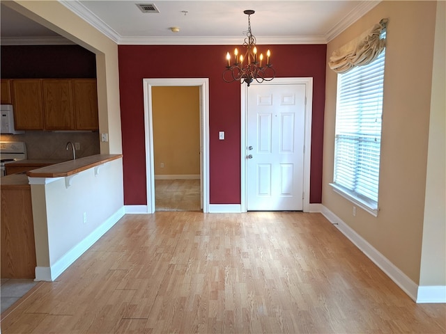 interior space featuring a chandelier, crown molding, and light hardwood / wood-style floors