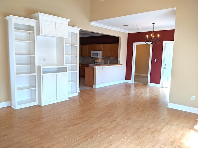 kitchen featuring a notable chandelier, a breakfast bar, white appliances, hanging light fixtures, and built in shelves