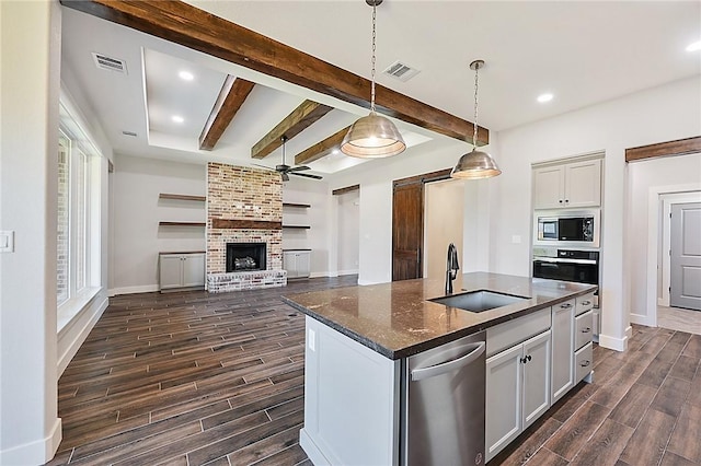 2803 Spector Dr, Bryan, TX 77808 - kitchen with stainless steel appliances, a sink, wood finish floors, ceiling fan, and beamed ceiling