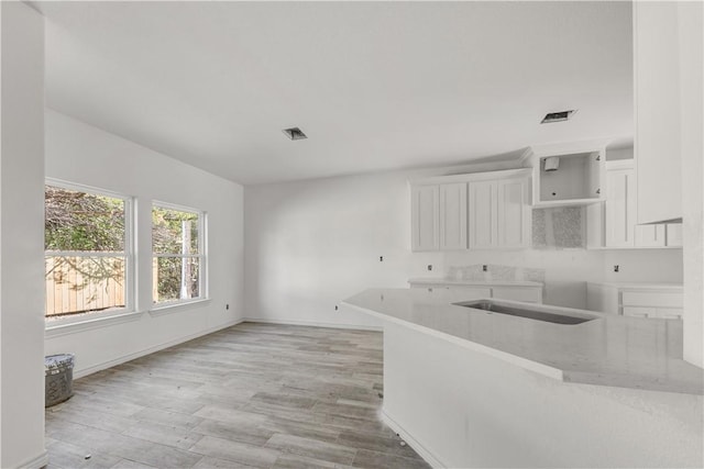 kitchen featuring white cabinetry, sink, and light wood-type flooring