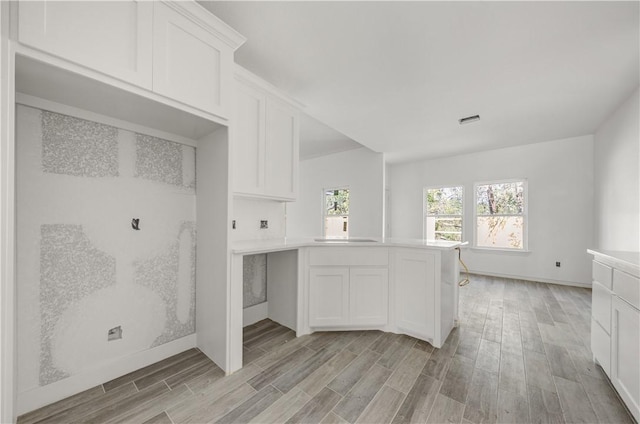 kitchen with sink, white cabinets, and light hardwood / wood-style floors