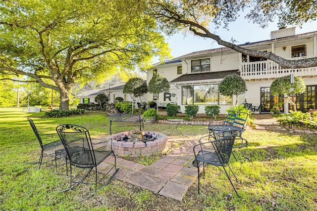 601 E Collard St, Madisonville, TX 77864 - back of property with a lawn, an outdoor fire pit, stucco siding, and a patio area