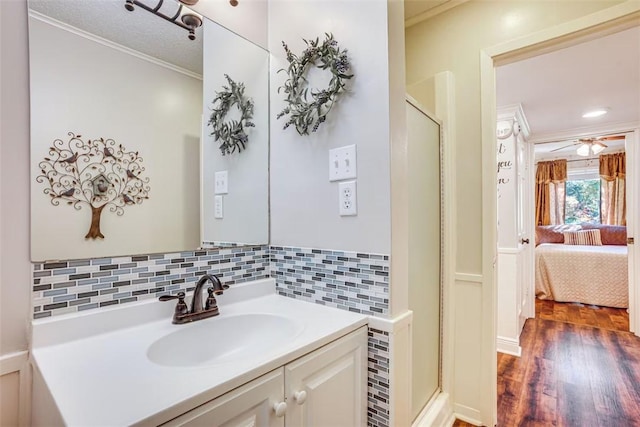 601 E Collard St, Madisonville, TX 77864 - bathroom with a shower stall, crown molding, wood finished floors, vanity, and decorative backsplash
