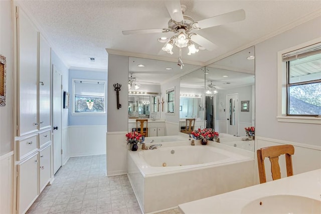 601 E Collard St, Madisonville, TX 77864 - bathroom with ceiling fan, a whirlpool tub, crown molding, vanity, and a wainscoted wall