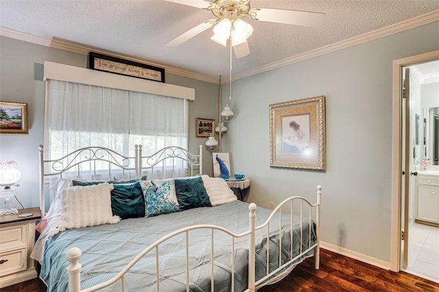 601 E Collard St, Madisonville, TX 77864 - bedroom with wood finished floors, ornamental molding, ensuite bath, ceiling fan, and baseboards