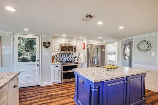 601 E Collard St, Madisonville, TX 77864 - kitchen featuring stainless steel appliances, dark wood-style flooring, white cabinets, decorative backsplash, and blue cabinets