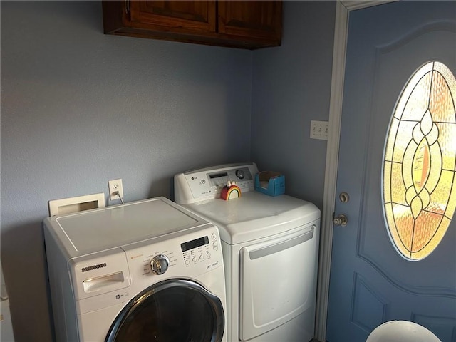 laundry room with washer and clothes dryer and cabinets