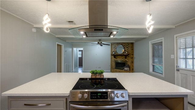 kitchen featuring visible vents, a brick fireplace, open floor plan, stainless steel electric range, and island range hood