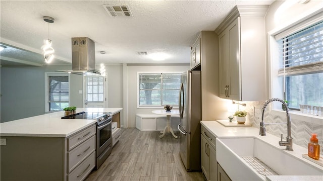kitchen featuring visible vents, gray cabinets, a sink, stainless steel appliances, and island range hood