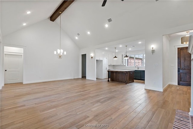 unfurnished living room featuring high vaulted ceiling, ceiling fan with notable chandelier, sink, light wood-type flooring, and beam ceiling