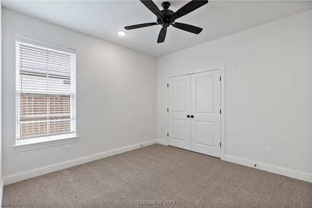 unfurnished bedroom featuring carpet, ceiling fan, and a closet