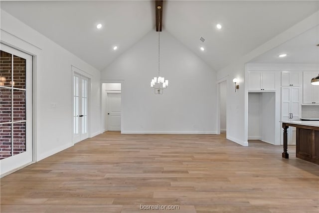 unfurnished living room with beamed ceiling, light hardwood / wood-style floors, high vaulted ceiling, and an inviting chandelier