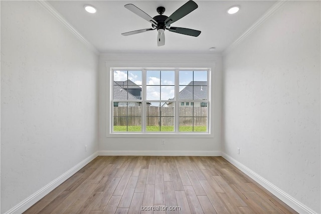 spare room with ceiling fan, ornamental molding, and light wood-type flooring