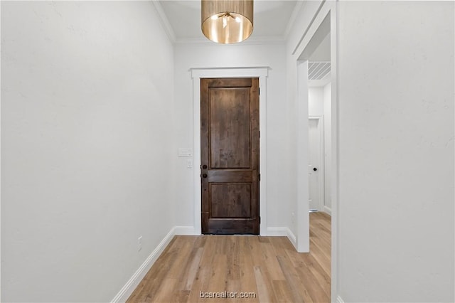 doorway to outside featuring light wood-type flooring and ornamental molding