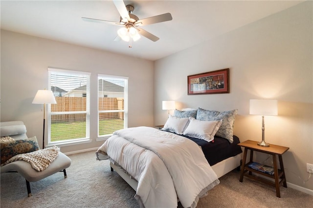 carpeted bedroom with ceiling fan and baseboards