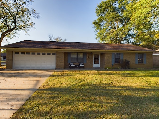 ranch-style house featuring a garage and a front lawn