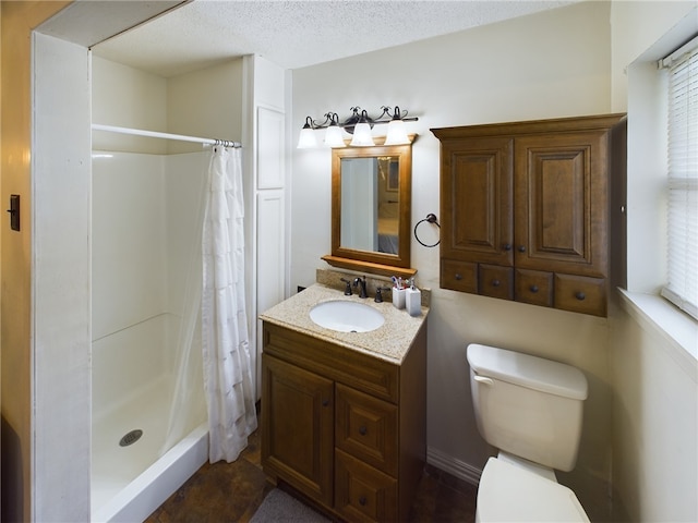 bathroom with toilet, vanity, a textured ceiling, and walk in shower