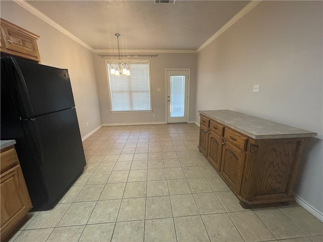kitchen featuring baseboards, freestanding refrigerator, a chandelier, crown molding, and light tile patterned floors