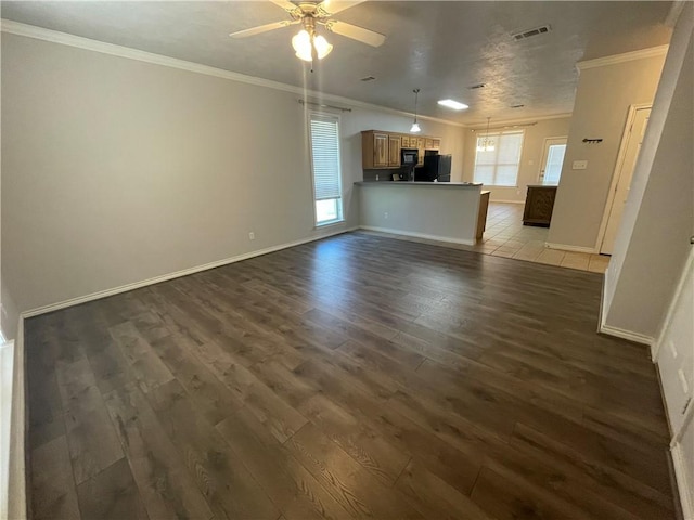 unfurnished living room with wood finished floors, ceiling fan, baseboards, ornamental molding, and visible vents