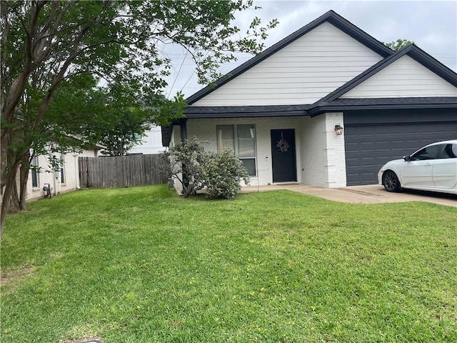 view of front facade with a front lawn, driveway, fence, a garage, and brick siding