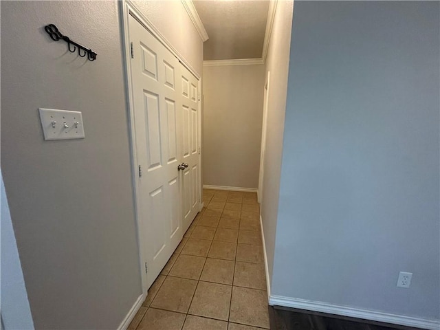 hallway with baseboards, light tile patterned flooring, and crown molding