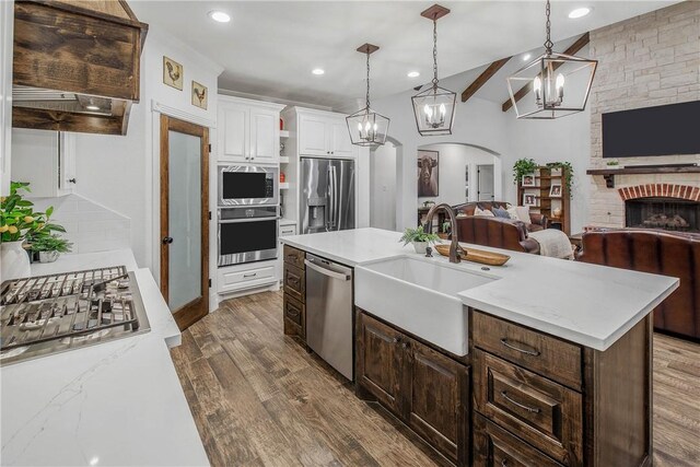 2181 Fm 166, Caldwell, TX 77836 - kitchen featuring appliances with stainless steel finishes, a sink, open floor plan, wood finished floors, and white cabinetry