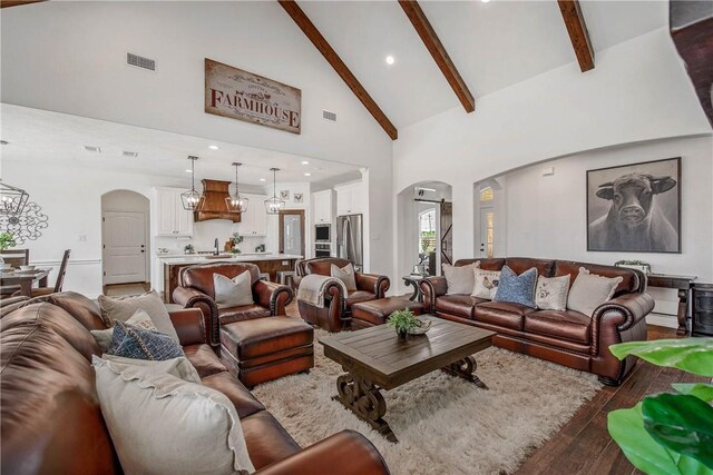 2181 Fm 166, Caldwell, TX 77836 - living area with arched walkways, high vaulted ceiling, wood-type flooring, beam ceiling, and a chandelier