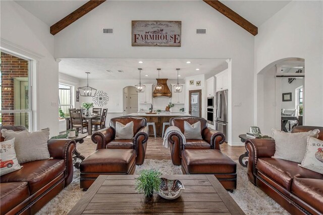 2181 Fm 166, Caldwell, TX 77836 - living room featuring arched walkways, high vaulted ceiling, light wood-style floors, and beamed ceiling