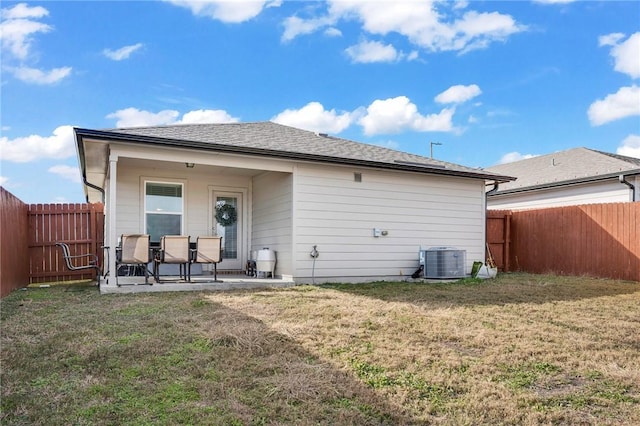 rear view of property featuring central AC unit, a patio area, and a yard